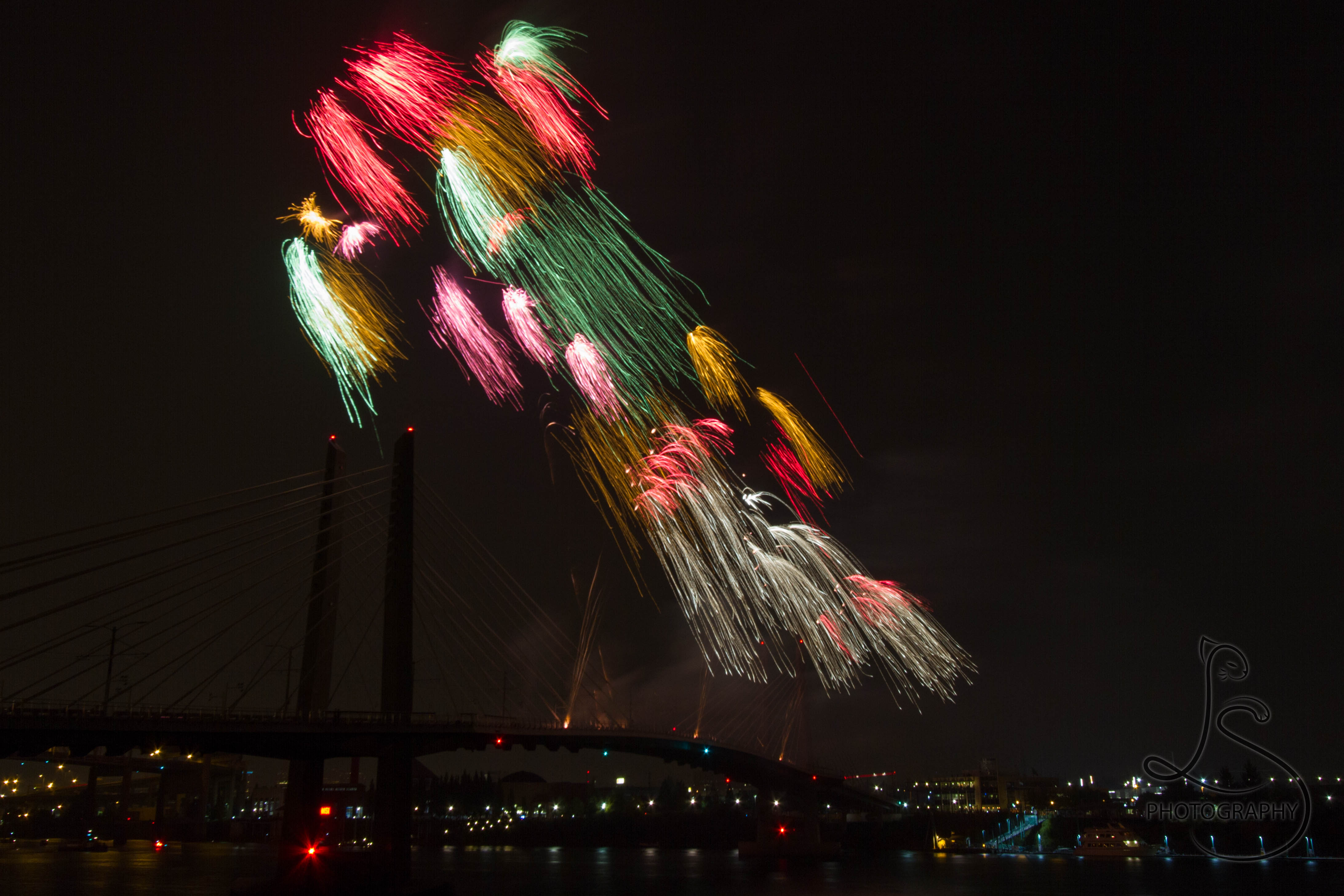 Multicolored streams of fireworks lighting the sky above Portland's Tilikum Crossing | LotsaSmiles Photograhy