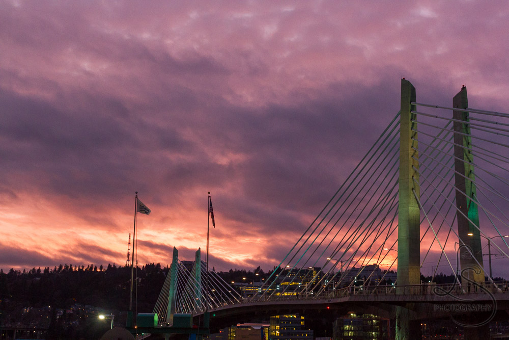 A fiery sunset sky behind Portland's Tilikum Crossing bridge | LotsaSmiles Photography