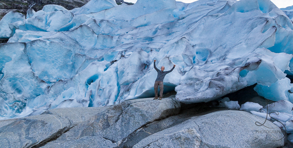 Aaron posing in front of the massive Nigardsbreen Glacier in Norway | LotsaSmiles Photography